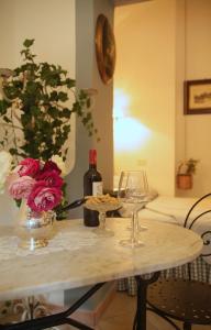 a table with a bottle of wine and two wine glasses at B&B del Giglio in Cefalù