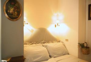 a bed with two pillows in a room with two lights at B&B del Giglio in Cefalù