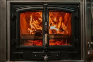 un feu dans une cuisinière avec ses portes ouvertes dans l'établissement Hotel A Veiga, à Samos