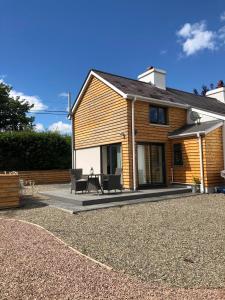 Casa de madera con 2 sillas y mesa en Carreglwyd, en Llandeilo