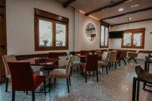 jadalnia ze stołami, krzesłami i oknami w obiekcie Hotel A Veiga w mieście Samos