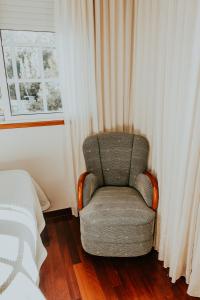 krzesło siedzące w sypialni obok okna w obiekcie Hotel A Veiga w mieście Samos