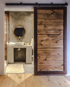 a bathroom with a wooden door with a sink and a mirror at Anastasis in Cape Town