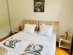- une chambre avec un lit doté de draps et d'oreillers blancs dans l'établissement Lavender Bay Apartment F7, à Donji Morinj