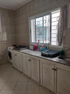 a kitchen with a sink and a washing machine at Martil Vacation Apartment in Martil
