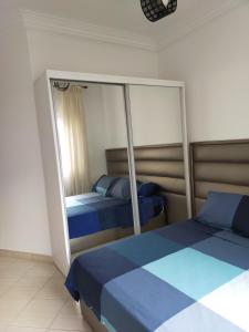 a bedroom with two beds and a mirror at Martil Vacation Apartment in Martil