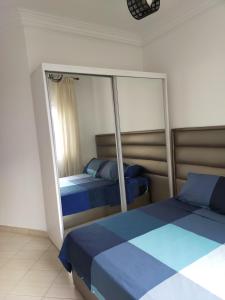 a bedroom with two beds and a mirror at Martil Vacation Apartment in Martil +13 photos