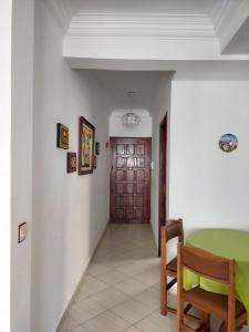 a hallway with a table and a wooden door at Martil Vacation Apartment in Martil