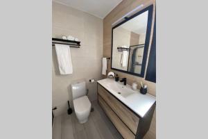 ein Badezimmer mit Toilette, Waschbecken und Spiegel in der Unterkunft Miravent Terraza y Jardin Frente al mar Menorca in Fornells + 68 Fotos