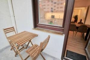 une table et des chaises assises à côté d'une fenêtre dans l'établissement Fantastische Moderne und Zentrale Wohnung mit Balkon, à Mannheim