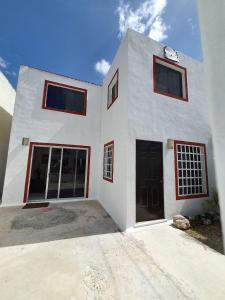 un edificio blanco con dos puertas y dos ventanas en HOSPEDAJE HOLY, en Mérida