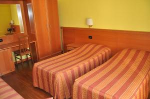 a hotel room with two beds and a desk at Friendship Palace in Rome