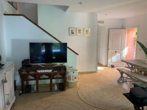 salon z telewizorem z płaskim ekranem na stole w obiekcie CASA 4 HABITACIONES CON JARDIN 10 Pax w mieście Zahara de los Atunes