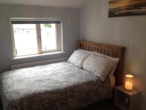 a small bedroom with a bed with a window at Glaslough Ramblers Rest in Monaghan