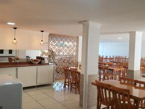a kitchen and dining room with tables and chairs at Pousada Recanto do Cowboy in Penha