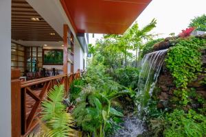 a waterfall in a garden next to a restaurant at Monte Maesot hotel in Mae Sot
