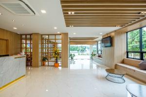 a lobby of a building with a table and chairs at Monte Maesot hotel in Mae Sot