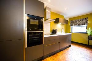 a kitchen with stainless steel appliances and yellow walls at Maison Parfaite LS1 - Luxury City Centre Suites in Leeds