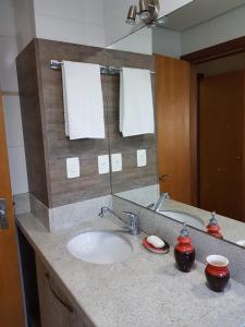 encimera con lavabo y espejo en Apartamento Gramado, en Gramado