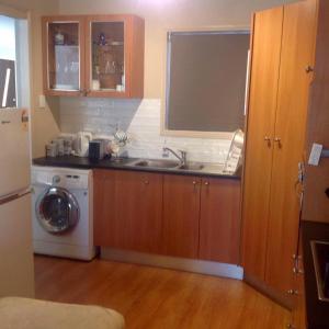 a kitchen with a sink and a washing machine at Brisbane Bayside Retreat in Birkdale