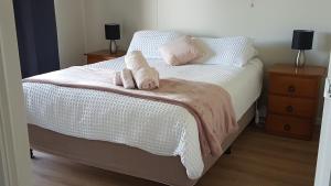 una camera da letto con un letto e due asciugamani di White Cedar Cottage a Booroobin