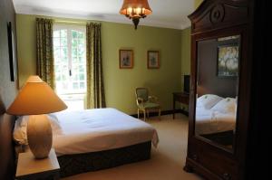 a bedroom with a bed and a lamp and a mirror at Hostellerie Restaurant Les Gorges de l'Aveyron in Bruniquel +76 photos