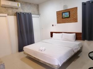 a bedroom with a bed with white sheets at เพ็ญวิวรีสอร์ท in Ban Dong Sai