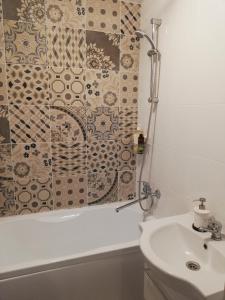 a bathroom with a shower curtain and a sink at Apartment HOLIDAY HOUSE in Sukko