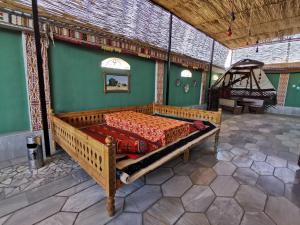 1 dormitorio con cama de madera en una habitación en BESQALA, en Nukus