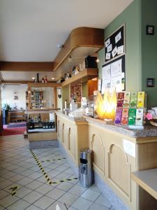 una cafetería con un mostrador en una tienda en Hotel B&B Francolini, en Folgaria