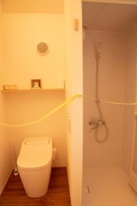 a white bathroom with a toilet and a shower at match guest house（まっちゲストハウス） in Tatsugo