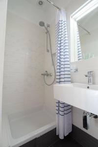 a white bathroom with a sink and a shower at Plaza 1 in Sveti Juraj +57 photos