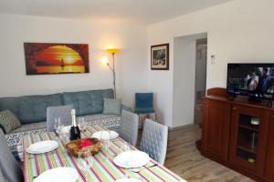 una sala de estar con una mesa y un sofá en Residence Villa Fiore Portorož, en Portorož