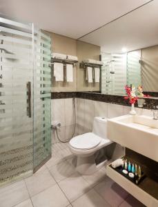 uma casa de banho com um WC, um chuveiro e um lavatório. em Le Park Concord Hotel - Turaif em Turaif