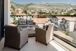 a balcony with chairs and a view of a city at Apartmans Centar in Trebinje