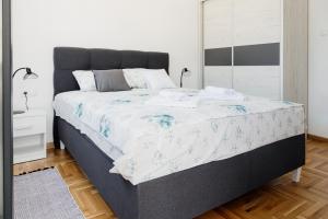 ein Schlafzimmer mit einem großen Bett und einem Spiegel in der Unterkunft Apartmans Centar in Trebinje