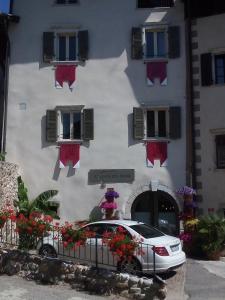 a car parked in front of a building with flowers at Agriturismo La Ciasa Del Fabio in Tassullo