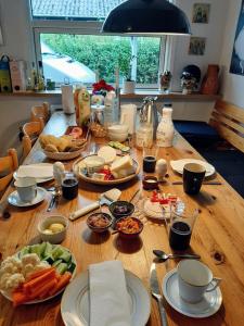 una mesa de madera con platos de comida. en Woody B&B en Jelling