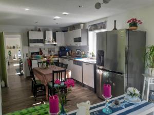 uma cozinha com uma mesa e um frigorífico de aço inoxidável em Ferienhaus Ciara em Splietsdorf