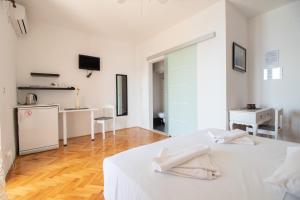 a white room with a bed and a kitchen at Plaza 1 in Sveti Juraj
