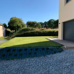 um jardim com plantas no cascalho ao lado de uma casa em La Bellangerie Gîte et Spa em Forcé