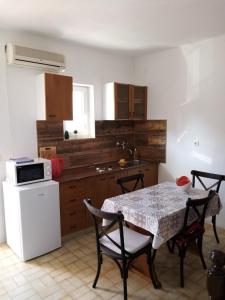 a kitchen with a table and a white refrigerator at Apartments Skipper in Seget Vranjica