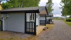 cobertizo pequeño con porche y terraza en Backgårdens Stugby, en Axvall