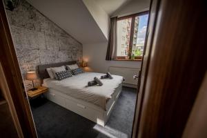 Un dormitorio con una cama con zapatos. en Top Apartments - Dunin Wąsowicza, en Cracovia