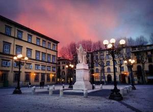 a building with a statue in the middle of a street at Piazza Napoleone Sweet apartment in Lucca