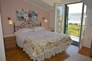 1 dormitorio con cama y ventana grande en Anita Apartments, en Trogir