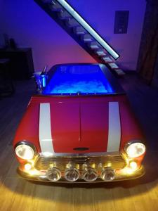 a red car in a room with a swimming pool at Le garage de Sophie in Aiguebelette-le-Lac