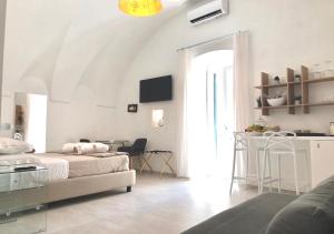 Vieste Suite في فييستي: غرفة بيضاء مع سرير وطاولة
