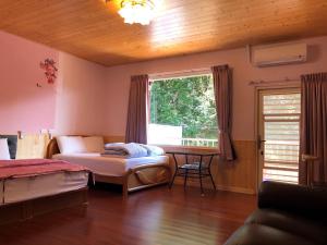 Schlafzimmer mit einem Bett, einem Schreibtisch und einem Fenster in der Unterkunft Chingjing ‧ orange Scotia in Renai