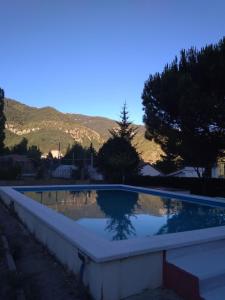 ein Schwimmbad in einem Garten mit Bergen im Hintergrund in der Unterkunft LAS AMAPOLAS in Arguis
